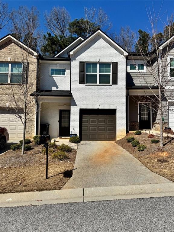 view of front of house with concrete driveway, a garage, and brick siding