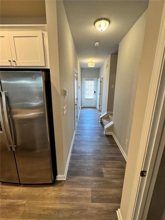 hall featuring baseboards and dark wood-style flooring