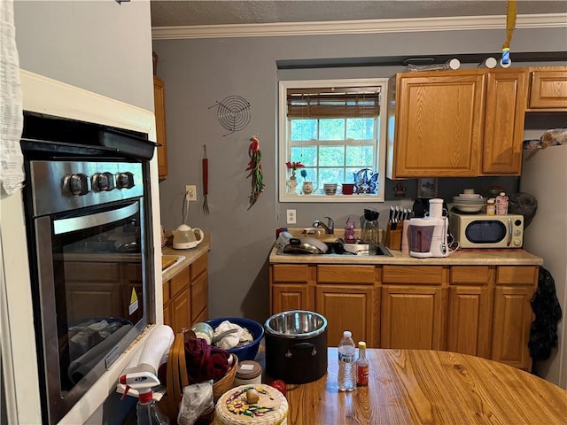 703 Jack Sharp Rd, Colbert, GA 30628 - kitchen featuring stainless steel appliances, light countertops, brown cabinets, and ornamental molding