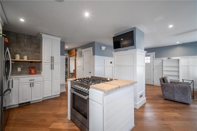 kitchen featuring backsplash, stainless steel appliances, light wood-type flooring, and white cabinets