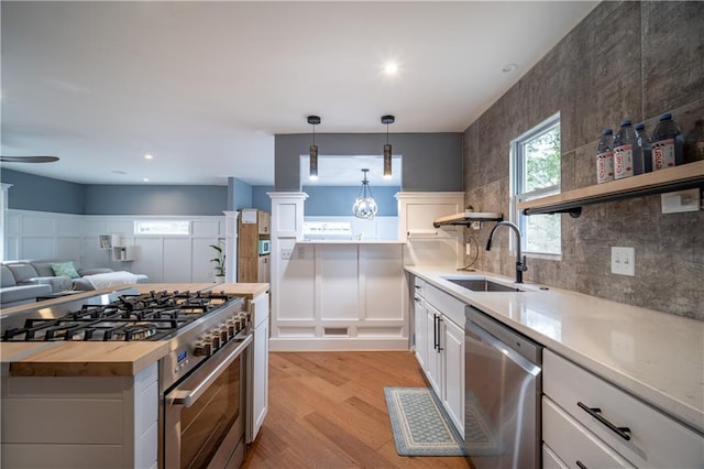 kitchen featuring sink, white cabinetry, wooden counters, light wood-type flooring, and appliances with stainless steel finishes