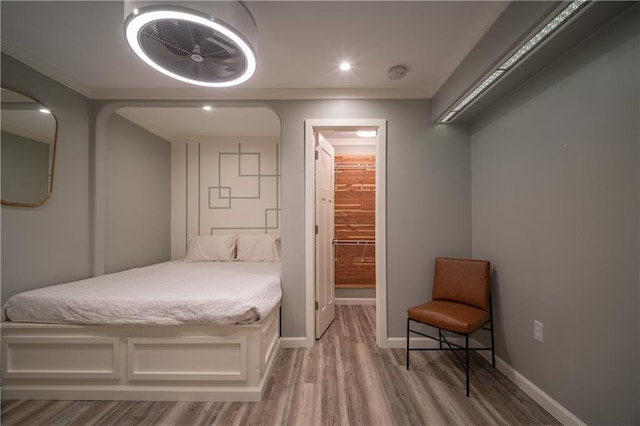 bedroom with ornamental molding and light wood-type flooring