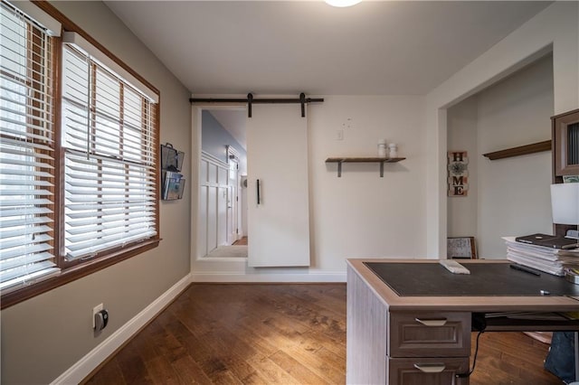 office area with dark wood-type flooring and a barn door