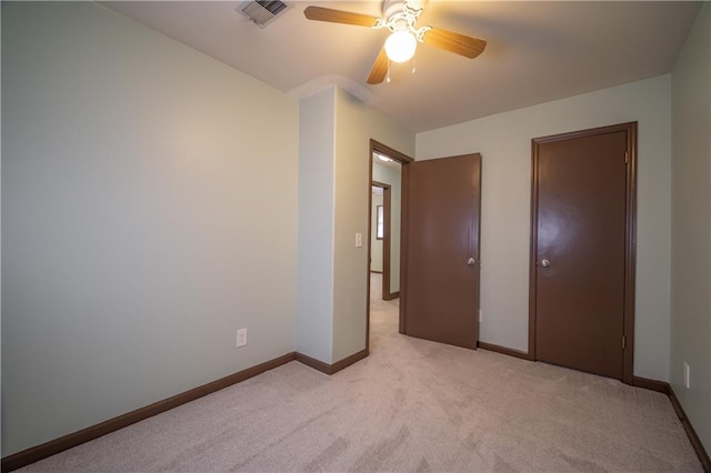 unfurnished bedroom featuring light colored carpet and ceiling fan