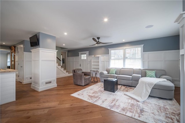 living room with light hardwood / wood-style floors and ceiling fan