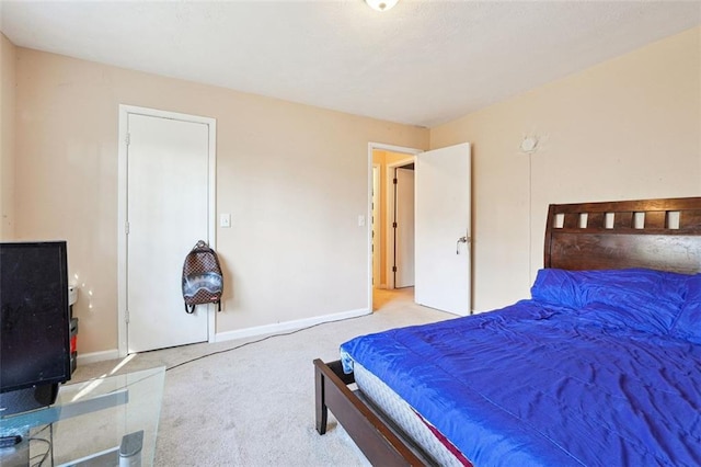 bedroom featuring light carpet and baseboards