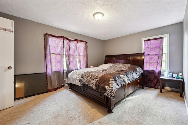 bedroom featuring a textured ceiling and light colored carpet