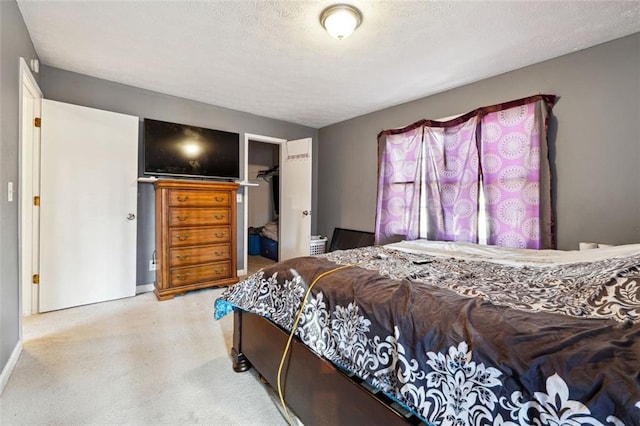 bedroom featuring a textured ceiling, a spacious closet, and a closet