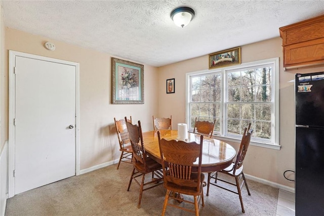 dining area with a textured ceiling, baseboards, and a healthy amount of sunlight