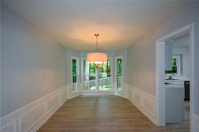 9050 Brockham Way, Alpharetta, GA 30022 - unfurnished dining area featuring a decorative wall, healthy amount of natural light, wainscoting, wood finished floors, and a sink