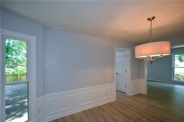 9050 Brockham Way, Alpharetta, GA 30022 - unfurnished dining area featuring wood finished floors, wainscoting, a chandelier, and a decorative wall
