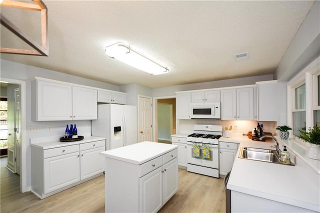 9050 Brockham Way, Alpharetta, GA 30022 - kitchen featuring white appliances, a sink, white cabinetry, light wood-type flooring, and light countertops