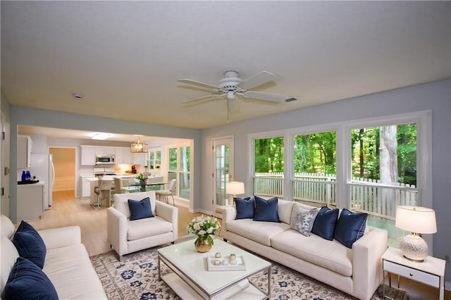 9050 Brockham Way, Alpharetta, GA 30022 - living area featuring a ceiling fan, plenty of natural light, baseboards, and light wood-style floors