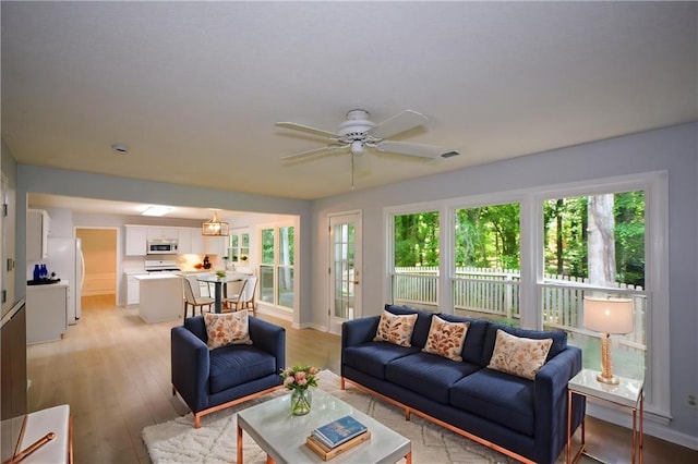 9050 Brockham Way, Alpharetta, GA 30022 - living area featuring plenty of natural light, light wood-style flooring, a ceiling fan, and baseboards
