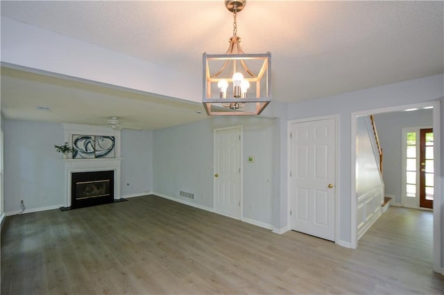 9050 Brockham Way, Alpharetta, GA 30022 - unfurnished living room with wood finished floors, a chandelier, and baseboards