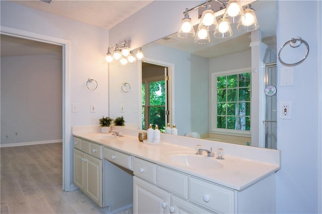 9050 Brockham Way, Alpharetta, GA 30022 - bathroom with double vanity, a chandelier, wood finished floors, and baseboards