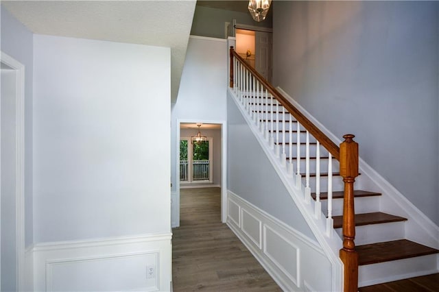 9050 Brockham Way, Alpharetta, GA 30022 - stairs with a chandelier, wainscoting, wood finished floors, and a decorative wall