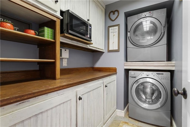 clothes washing area with stacked washing maching and dryer