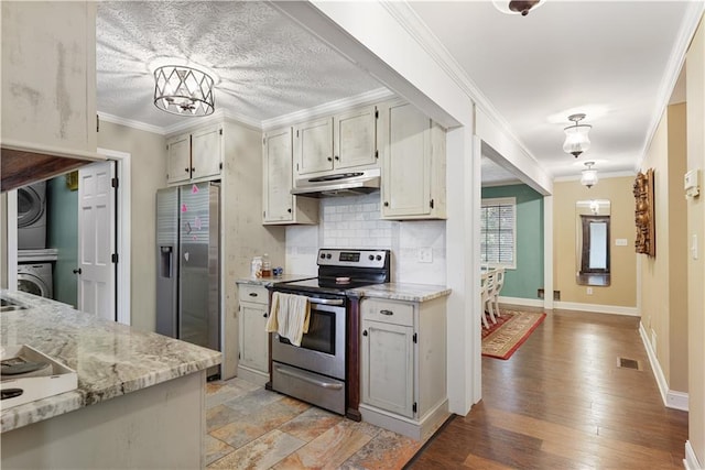 kitchen featuring appliances with stainless steel finishes, ornamental molding, light hardwood / wood-style floors, light stone counters, and stacked washer and clothes dryer