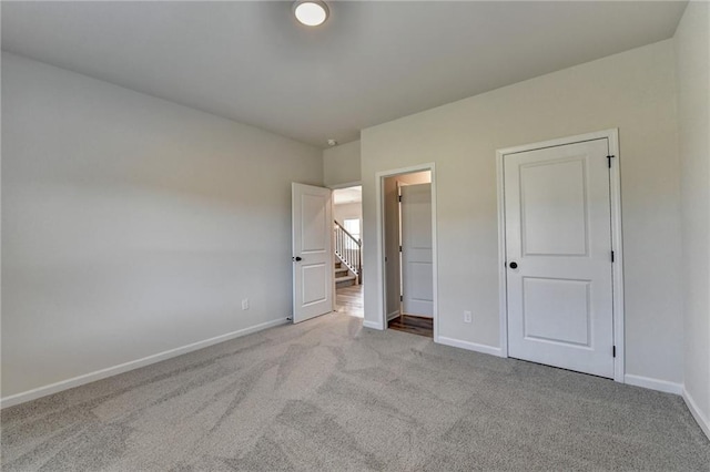 unfurnished bedroom featuring light carpet and a closet