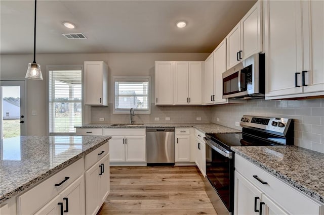 kitchen featuring white cabinetry, sink, stainless steel appliances, tasteful backsplash, and pendant lighting