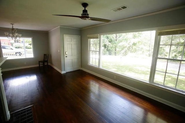 spare room with baseboards, visible vents, ornamental molding, dark wood-style flooring, and ceiling fan with notable chandelier