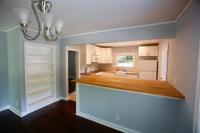 kitchen with white appliances, baseboards, wood counters, and a peninsula