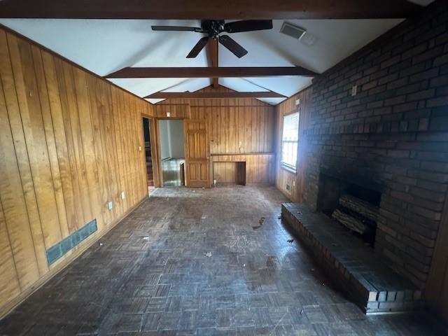 3415 Spring Valley Blvd, Atlanta, GA 30349 - unfurnished living room with wood walls, a ceiling fan, and a brick fireplace