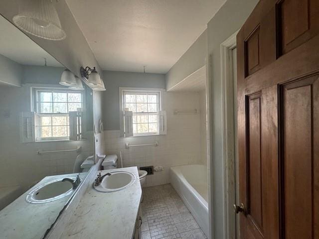 3415 Spring Valley Blvd, Atlanta, GA 30349 - bathroom featuring tile walls, vanity, and washtub / shower combination