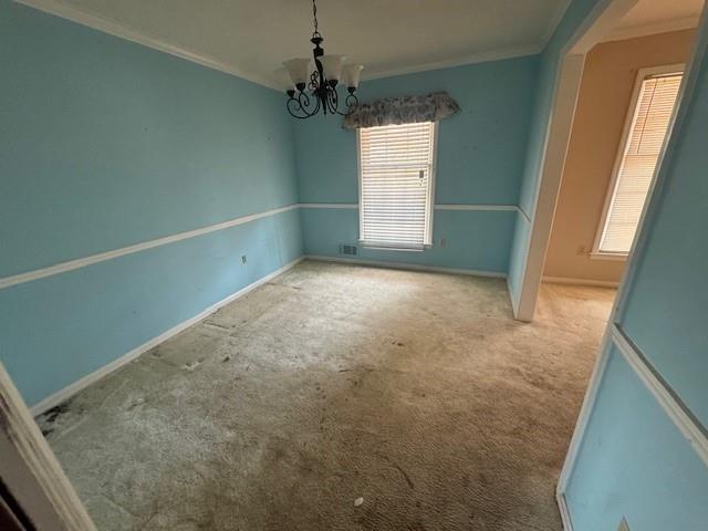 3415 Spring Valley Blvd, Atlanta, GA 30349 - carpeted spare room with crown molding and a chandelier