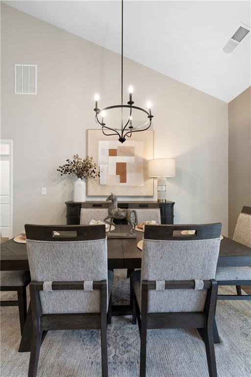dining room featuring high vaulted ceiling and a chandelier