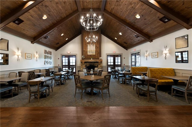 dining space with hardwood / wood-style floors, a chandelier, wood ceiling, high vaulted ceiling, and beamed ceiling