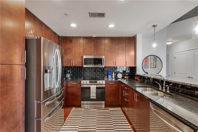 kitchen featuring appliances with stainless steel finishes, a sink, visible vents, and decorative backsplash