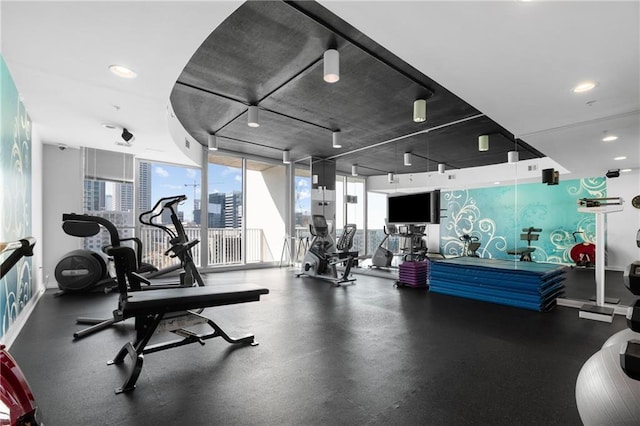 workout area with expansive windows and baseboards