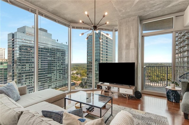 living room with expansive windows, an inviting chandelier, and wood finished floors