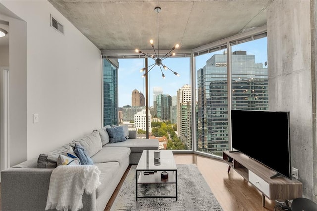 living room with visible vents, floor to ceiling windows, a chandelier, and wood finished floors