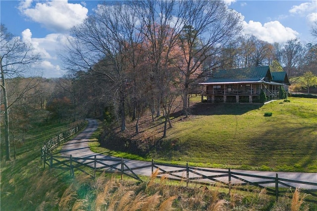view of community featuring fence and a yard