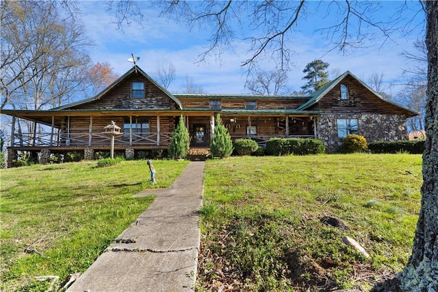 log home with covered porch, log siding, and a front lawn