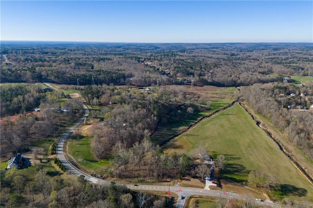 bird's eye view with a wooded view