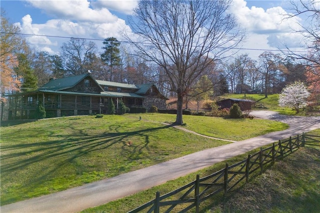 view of home's community featuring a lawn and fence