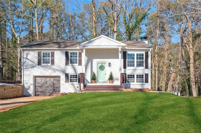 split foyer home featuring a garage and a front lawn