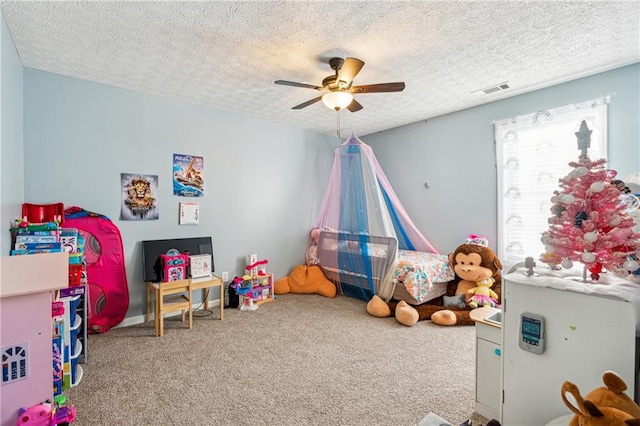 game room featuring carpet, ceiling fan, and a textured ceiling