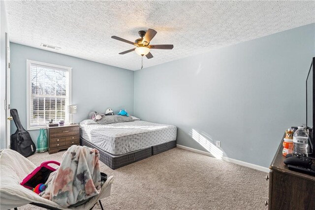 bedroom featuring ceiling fan, carpet floors, and a textured ceiling