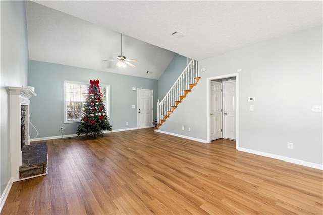 unfurnished living room with ceiling fan, vaulted ceiling, and light wood-type flooring