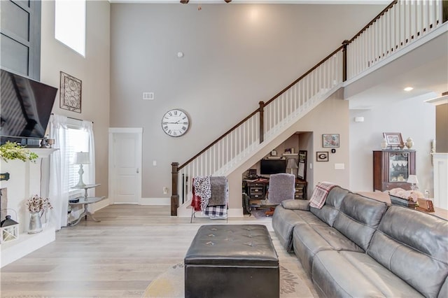 living room with light hardwood / wood-style flooring and a high ceiling