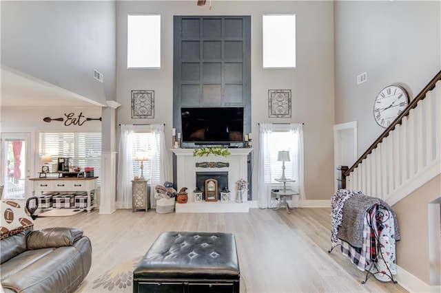 living room with a fireplace, hardwood / wood-style floors, and a high ceiling