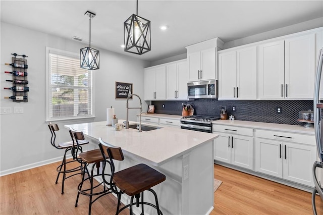 232 Northridge Dr, Dallas, GA 30132 - kitchen featuring appliances with stainless steel finishes, a sink, an island with sink, backsplash, and light countertops