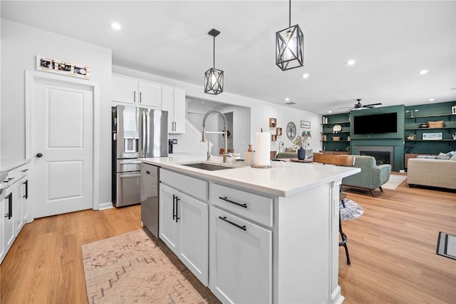 232 Northridge Dr, Dallas, GA 30132 - kitchen with a sink, appliances with stainless steel finishes, ceiling fan, light wood-type flooring, and a fireplace