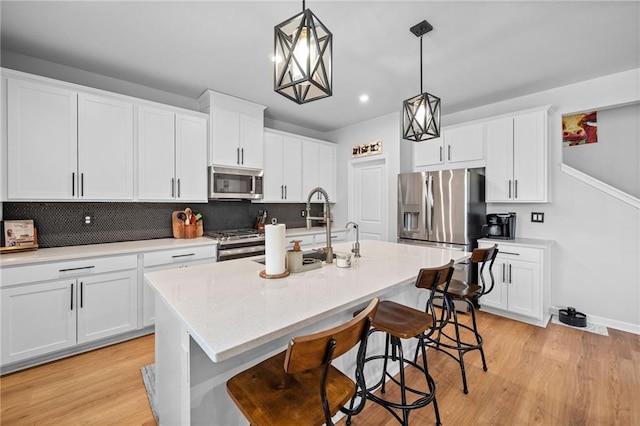 232 Northridge Dr, Dallas, GA 30132 - kitchen with stainless steel appliances, a breakfast bar, an island with sink, backsplash, and decorative light fixtures