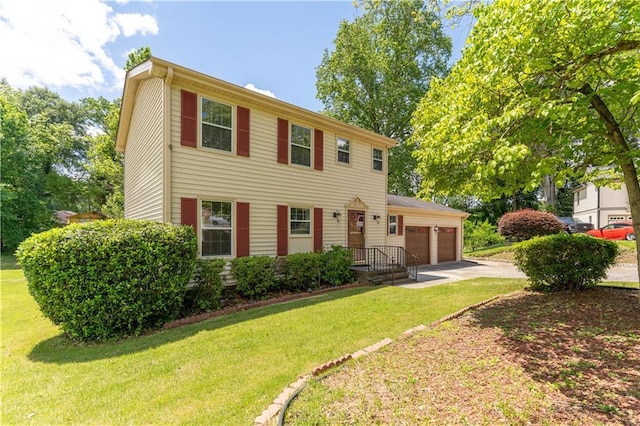 colonial home featuring an attached garage, concrete driveway, and a front lawn